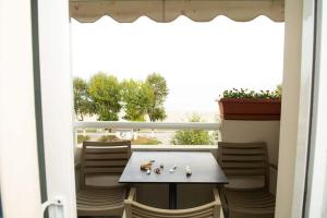 奥林匹亚基·阿克蒂Giorgos Apartments Sea View的阳台配有桌椅和窗户