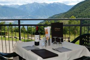 特龙扎诺拉戈马焦雷阿尔德格戴安娜酒店的一张桌子,上面放着一瓶葡萄酒和眼镜