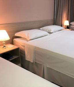 热基耶Hotel San Remo的一张位于酒店客房的两张床,配有一张桌子上的灯