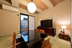 京都竹屋西阵豪华町屋的客厅配有电视和桌椅