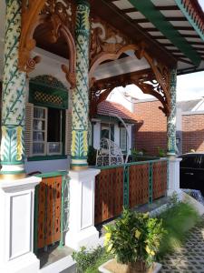 日惹Rumah Jawa Guest House (Syariah)的房屋设有门廊和木栅栏