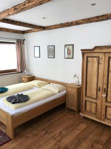 图克斯Tuxie Haus的一间卧室配有一张床和一个木制橱柜