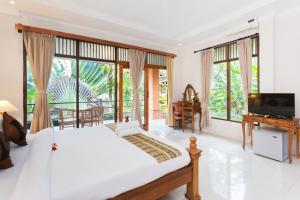 乌布乌布圣猴森林拉哈宇酒店的一间卧室设有一张床、一台电视和窗户。