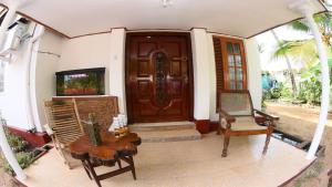 瓦都瓦Suriya Ocean Villa的房屋的前门,房子配有桌子和椅子