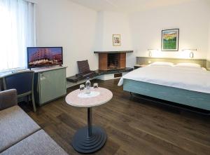 迪蒂孔萨梅劳提契诺瑞士品质酒店的一间酒店客房,配有一张床、一台电视和一张桌子