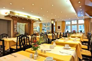 科隆维克托亚酒店的餐厅设有黄色桌椅和黄色桌布