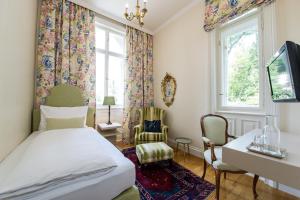 沃尔特湖畔佩莎赫德尔穆思酒店–帕克维拉沃尔斯的一间卧室配有一张床、一张书桌和一个窗户。