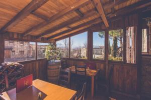 Barajas de GredosHotel Rural La Dehesilla的餐厅设有木桌、椅子和窗户。