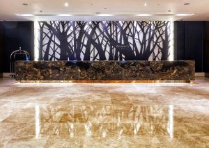 首尔首尔情侣酒店的大堂设有大理石地板和树木茂密的墙壁