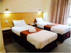 伦敦西克伦威尔酒店的酒店客房设有两张床和窗户。