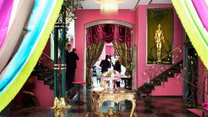 哥德堡朵西亚酒店及餐厅的粉红色的房间,配有桌子和镜子