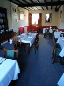 金顿The Royal Oak的用餐室配有桌椅和白色的桌布