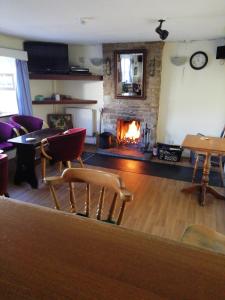 金顿The Royal Oak的客厅设有壁炉、椅子和桌子