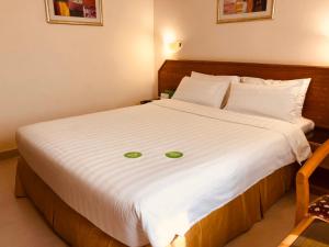 马斯喀特地那假日酒店的卧室配有一张白色的床,面部