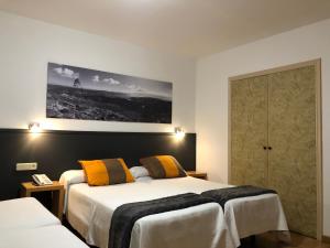 维戈维哥海滨酒店的酒店客房设有两张床,墙上挂着一张照片。