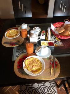 库斯科Casa Salkantay Cusco的餐桌上放有食物和橙汁
