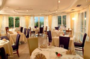 博尔扎诺汉妮酒店的餐厅设有白色的桌椅和窗户。