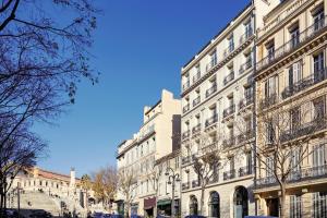 马赛ibis Styles Marseille Gare Saint-Charles的街道上带阳台的大型白色建筑