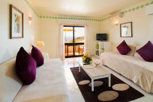 拉戈斯马尔阿祖尔别墅酒店的客厅配有沙发和桌子