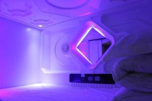 武汉武汉无忧太空舱酒店的一间设有镜子和紫色灯的房间