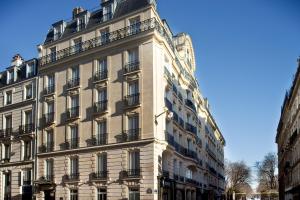 巴黎Hôtel Perreyve - Jardin du Luxembourg的街道上带阳台的大型白色建筑