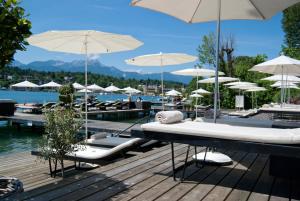 沃尔特湖畔韦尔登珀斯特兰酒店的木制甲板上配有椅子和遮阳伞的游泳池