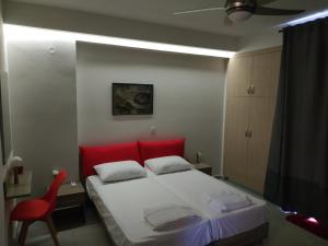 干尼亚The 3 Brothers' Apts的一间卧室配有红色的床和红色椅子