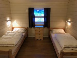 斯沃尔韦尔罗弗敦小木屋假日公园的带窗户的客房内的两张床