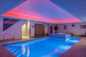 奥塞特奥塞特大厦酒店的一座建筑中一座带紫色灯光的游泳池