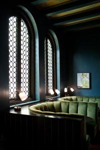洛杉矶圣莫尼卡帕里豪斯酒店的一间等候室,配有绿色椅子和2扇窗户