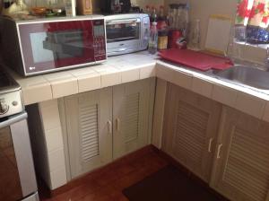 坎昆Mariposas Rooms的厨房柜台配有微波炉和水槽