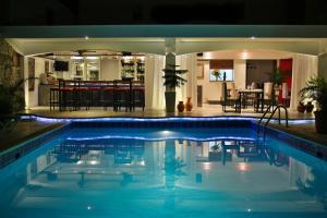 苏莎亚Hotel Las Palmeras的夜间游泳池,酒吧背景