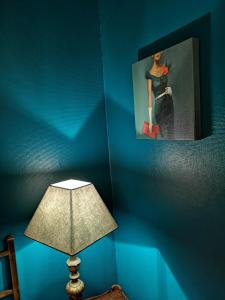洛代夫La Roseraie的蓝色的房间,带一盏灯和一个女人的照片