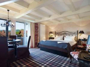 波彭豪森兰道思霍夫瓦瑟库佩酒店的一间卧室配有一张床、一张桌子和一把椅子