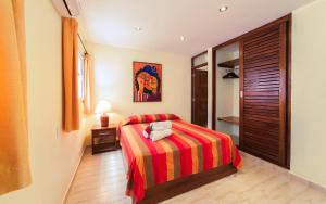 苏莎亚Hotel Las Palmeras的一间卧室配有一张带红色和黄色条纹毯子的床