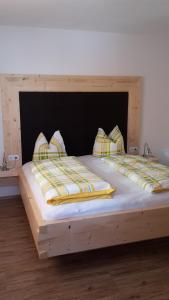 齐勒河谷采尔Ferienwohnung Tobias的一张木制床,上面有两个枕头