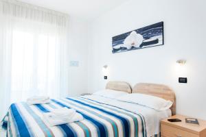 里米尼希格诺公寓酒店的一间卧室配有一张床,上面有两条毛巾
