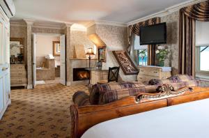 纽波特海滩Doryman's Oceanfront Inn的客厅设有一张床和一个壁炉