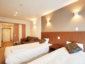 那霸Creass Hotel Tsubogawa Marche的酒店客房,设有两张床和一张沙发