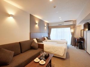 那霸Creass Hotel Tsubogawa Marche的酒店客房,设有两张床和一张沙发