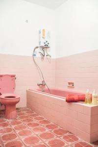 玛琅鲁马拉拉萨蒂旅舍的浴室设有粉红色的浴缸和粉红色的卫生间。