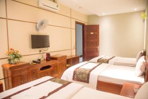老街市Khách Sạn Hoàng Gia Lào Cai - Hoang Gia Hotel的酒店客房设有两张床和电视。