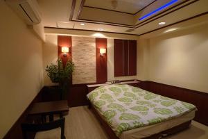 厚木Hotel GOLF Atsugi (Adult Only)的客房设有床、书桌、桌子和床筒。