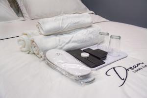 麻坡DREAM LUXURY HOTEL的床上的托盘,包括毛巾和其他物品