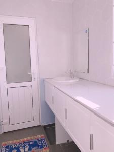 富国Sleep Box Hostel Phú Quốc的白色的浴室设有水槽和镜子