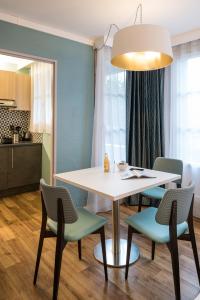 巴黎巴黎蒙马特爱达格公寓式酒店的一间配备有白色桌椅的用餐室