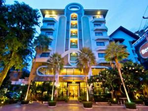 芭堤雅市中心最佳海滩别墅酒店的一座棕榈树环绕的大建筑