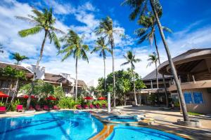 芭东海滩Coconut Village Resort Phuket - SHA Extra Plus的棕榈树度假村的游泳池
