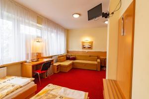 萨诺克Dom Sportowca Błonie - MOSiR的酒店客房,配有床和沙发