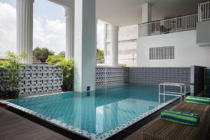日惹KHAS Tugu Hotel Yogyakarta的一座带两把椅子的建筑中的游泳池